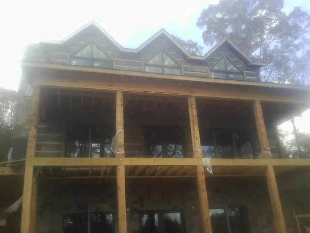 Dormers and porch framing on a large log home under construction in Ellisburg