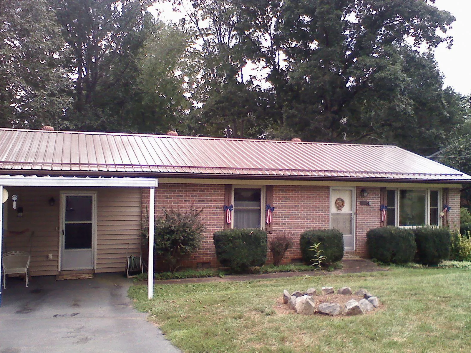 Bronze metal roof and carport on a brick ranch home — Roof Repair work by our crew in Ellisburg